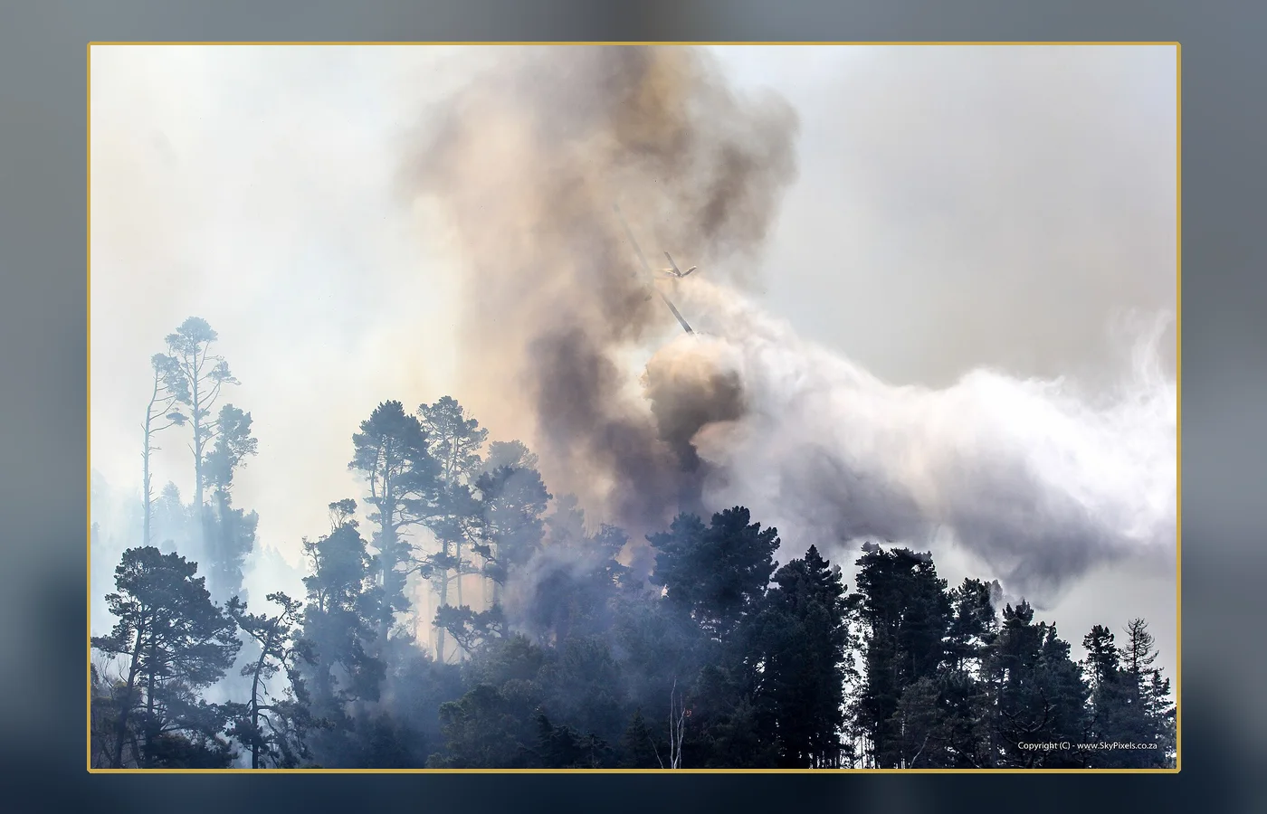 A modern wildfire-smoke scene photographed in deep daytime darkness, used as a labeled atmospheric comparison
